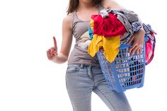 a woman is holding a laundry basket and giving the peace sign with her right hand