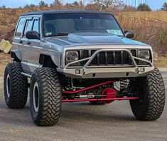 a silver jeep is parked on the street