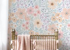 a baby's crib in front of a floral wallpaper with pink and yellow flowers