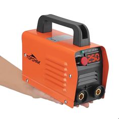 an orange portable inverter being held by a person's hand with the timer on it