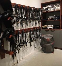 a room filled with lots of different types of horses'bridles hanging on the wall