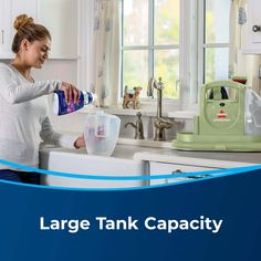 a woman is washing dishes in the kitchen with her hands on the faucet