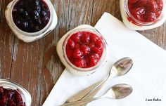 three jars filled with cherries sitting on top of a table next to spoons