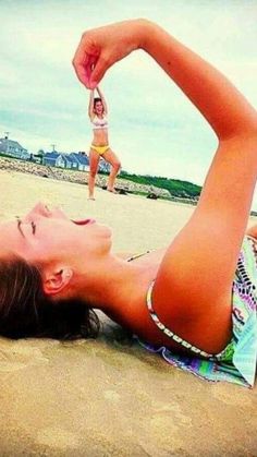 a woman laying on top of a sandy beach