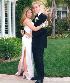 a man and woman in formal wear posing for a photo