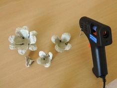 some white flowers on a wooden table and a black device with wires plugged into it