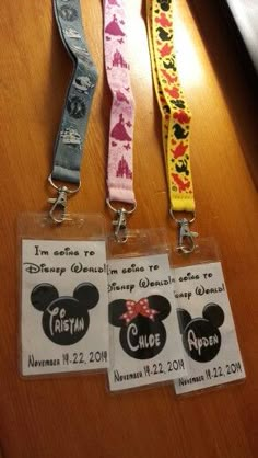 three lanyards with mickey and minnie mouse tags attached to them on a table