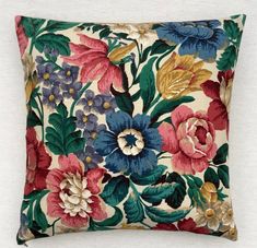 a colorful floral pillow on a white background