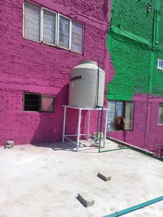 a large tank sitting in front of a pink building