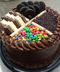 a chocolate cake topped with lots of candy and cookies