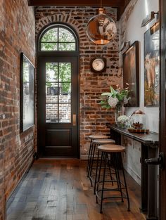 a brick wall with three stools in front of it and two clocks on the wall