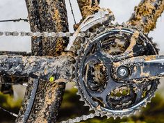 an old bicycle is covered in mud and dirt, with the chain still attached to it