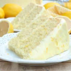 a slice of cake on a plate with lemons in the background