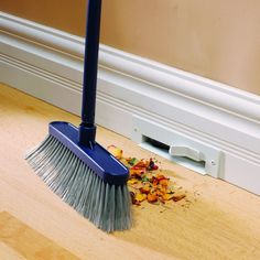 a broom is laying on the floor next to a pile of leaves and chips that have fallen from it