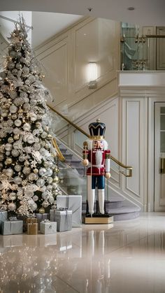 a christmas tree with a nutcracker statue next to it in front of a staircase