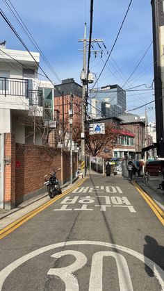 a motorcycle is parked on the side of an empty street with buildings in the background