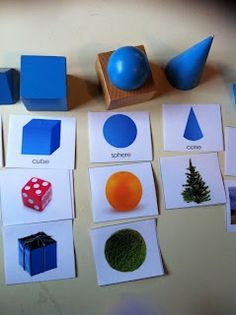 several different types of shapes and sizes are displayed on a table with blue blocks, dices, and balls