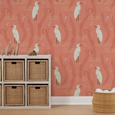 the wallpaper in this room is pink with white birds and reeds on it