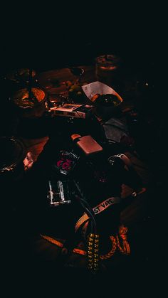 an assortment of items sitting on top of a table in the dark, with one person standing next to it