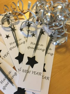 five new year's greetings with scissors and ribbons on a table top,