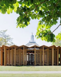 a wooden structure sitting on top of a lush green field