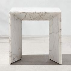 a white marble table sitting on top of a floor