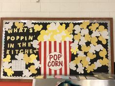 a popcorn box with the words pop corn written on it in front of a movie poster