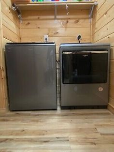 two new appliances in the corner of a small room with wood walls and flooring