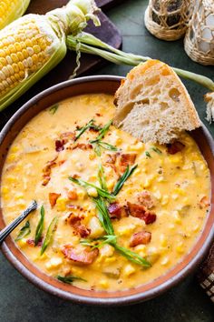 a bowl of corn chowee with a piece of bread sticking out of the side