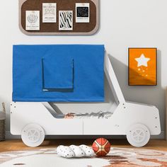 a child's room with a toy car bed and basketball balls on the floor