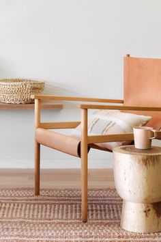 a chair and table in a living room with a rug on the floor next to it