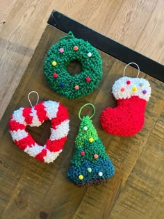 crocheted christmas ornaments are displayed on a wooden surface, including a stocking ornament