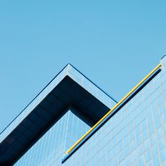 an airplane is flying in the blue sky above a building's glass front window