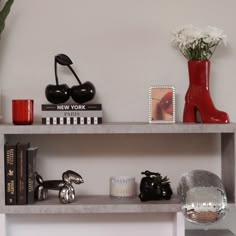 a shelf that has some books and vases on top of it next to other items