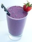 a purple smoothie in a glass with a straw and a strawberry on the top