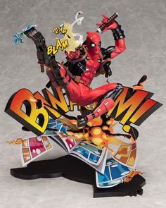 a deadpool action figure is posed on top of a skateboard with his arms in the air