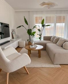 a living room filled with furniture and a flat screen tv mounted on a wall above a wooden coffee table