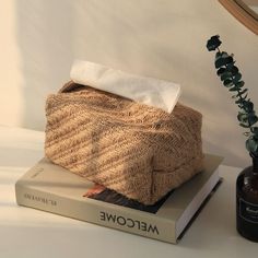 a stack of books sitting on top of a table next to a plant