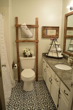 a white toilet sitting next to a sink in a bathroom under a wooden ladder above it