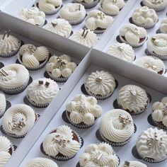 two boxes filled with white frosted cupcakes