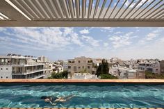 a person swimming in a pool next to some buildings