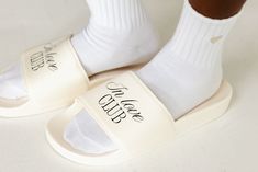 a person wearing white slippers and socks with the word love written on one side