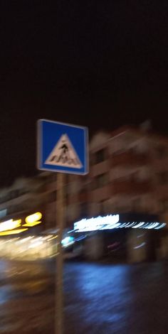 a blue and white street sign sitting on the side of a road next to a building