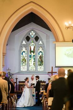 a bride and groom standing in front of the alter