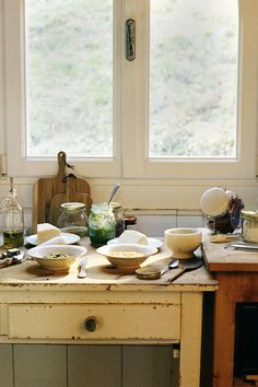 the kitchen counter is cluttered with dishes and utensils