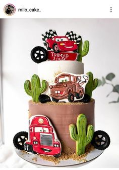 a three tiered cake decorated with cars and cactus