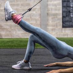 a woman is doing push ups on her stomach with a rope in front of her