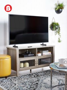 a flat screen tv sitting on top of a wooden entertainment center in a living room