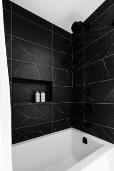 a black and white bathroom with marble tile