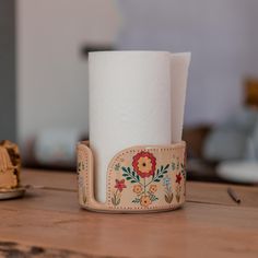 a roll of toilet paper sitting on top of a wooden table next to a toothbrush holder